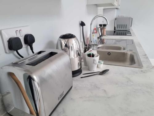 a kitchen counter with a toaster and a sink at Serene getaway Apartments in Maidstone