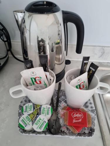 a tea pot and cups on top of a counter at Serene getaway Apartments in Maidstone