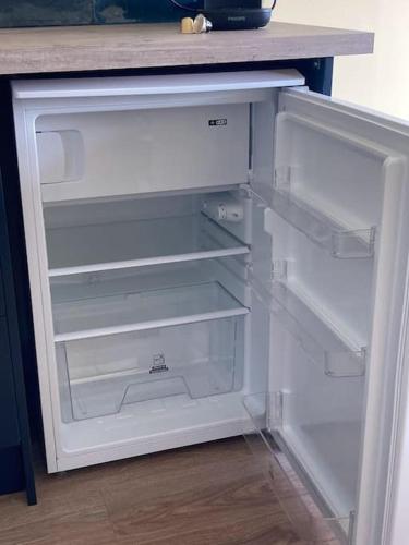 an empty refrigerator with its door open in a kitchen at Beautiful one bed with stunning sea view in Waterford
