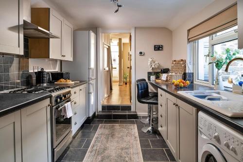 a kitchen with white cabinets and a counter top at Finest Retreats - Bwthyn Llechi, Slate Cottage in Blaenau-Ffestiniog