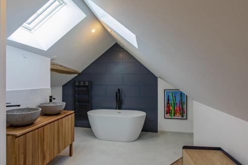 La salle de bains est pourvue d'une grande baignoire et d'un lavabo. dans l'établissement La Renaissance, à Saint-Dyé-sur-Loire