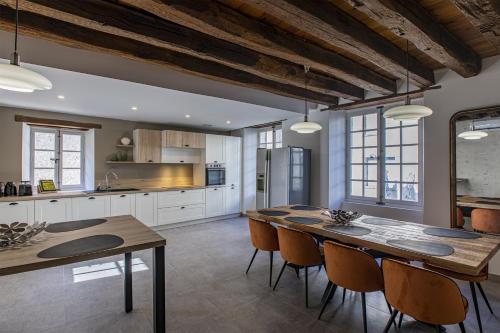 une grande cuisine avec une table et des chaises. dans l'établissement La Renaissance, à Saint-Dyé-sur-Loire