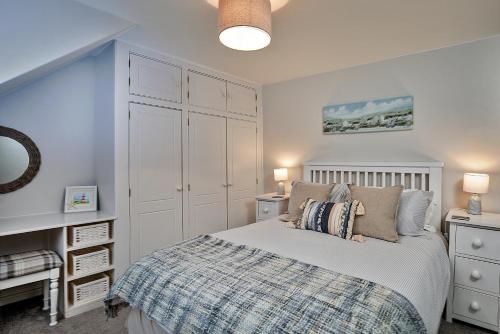 1 dormitorio con 1 cama y armario blanco en Finest Retreats - Old Salt Loft, en Whitby