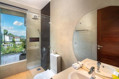 a bathroom with a shower and a sink and a mirror at Grand Serendib Hotel in Kandy