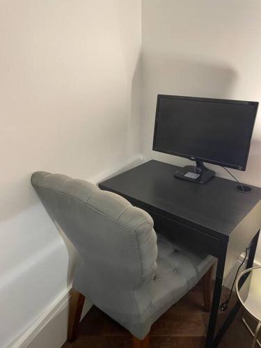 uma secretária com uma cadeira e um monitor de computador em The mini New-Yorker em Sydney