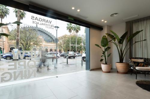a person walking past a glass door of a building at Petit Palace Vargas in Seville