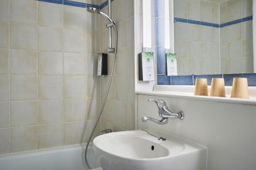 een badkamer met een wastafel en een douche bij Kyriad Niort - La Crèche in La Creche