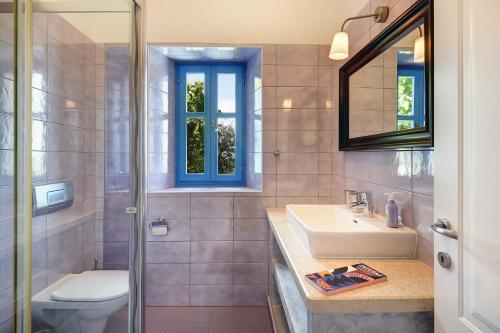 ein Badezimmer mit einem Waschbecken, einem WC und einem Spiegel in der Unterkunft Villa Nina in Vodnjan