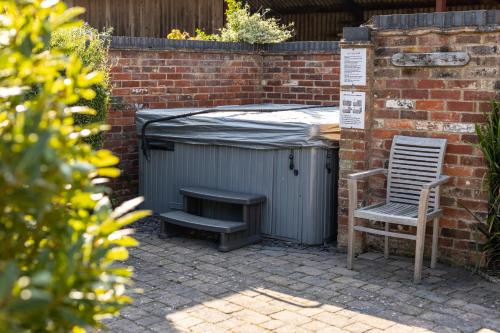 a table and a chair next to a trash can at Newclose Farm Cottages in Yarmouth