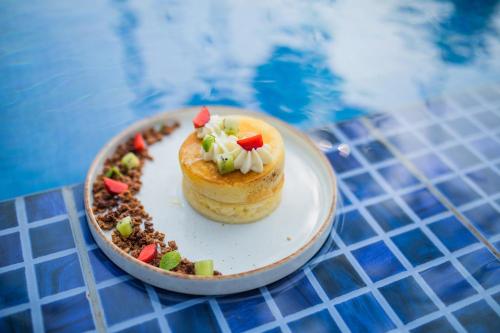 a dessert on a plate on a table next to a pool at Sawantwadi Palace Boutique Art Hotel in Sawantwadi