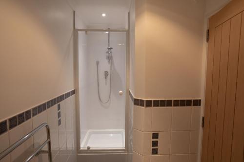 a bathroom with a shower with a glass door at Newclose Farm Cottages in Yarmouth