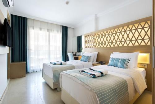 a hotel room with two beds in a room at Aurasia Deluxe Hotel in Marmaris