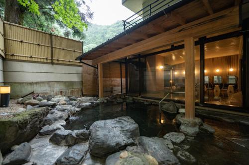 a house with a pond in front of a building at Sakahijiri Nikko in Nikko