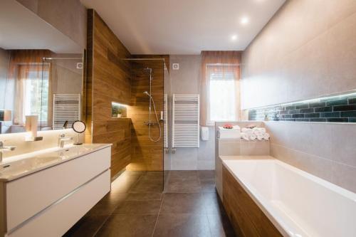 uma casa de banho com uma banheira, um lavatório e um chuveiro em Vámosi Party Ház em Vámosszabadi
