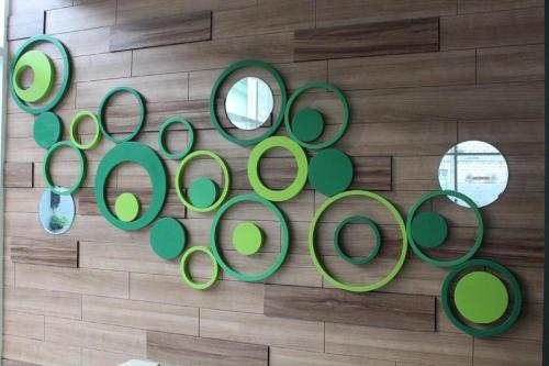 a group of green mirrors on a wall at KHAS Gresik in Gresik