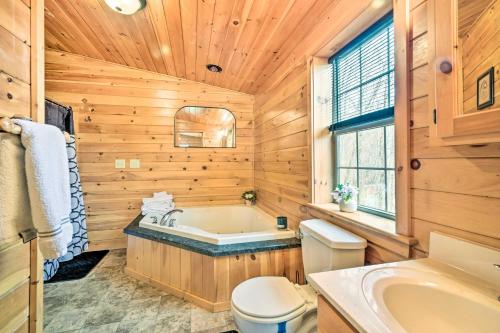 e bagno in legno con vasca, servizi igienici e lavandino. di Cozy Cabin in Parsons Hike, Fish and Explore! a Parsons
