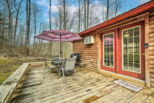 a wooden deck with a table and chairs and an umbrella at Cozy Cabin in Parsons Hike, Fish and Explore! in Parsons