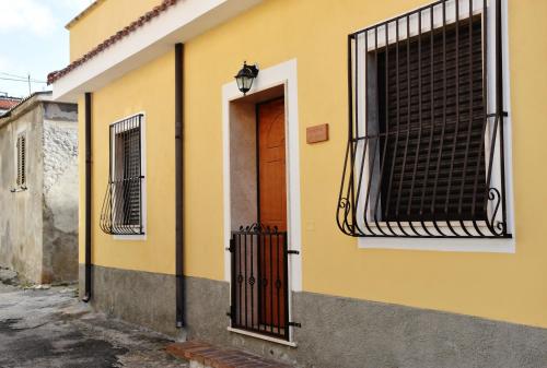 a yellow building with a door and a window at Residenza Le Sirene in Santa Domenica