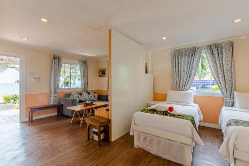 a hotel room with two beds and a desk at Pattaya Paradise Beach Resort in Na Jomtien