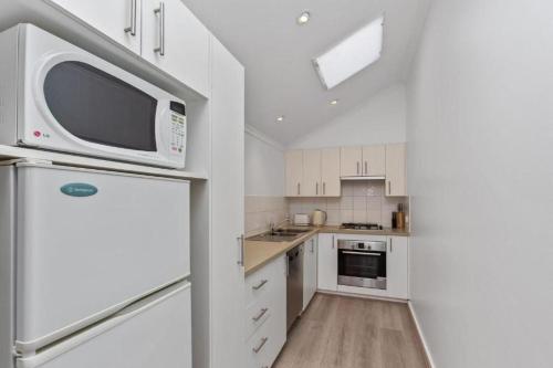 a kitchen with a refrigerator and a microwave at 15 Whitecrest Great Ocean Road Resort - Ocean View in Apollo Bay