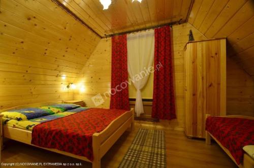 1 dormitorio con 1 cama en una cabaña de madera en Domek Góralski, en Zakopane