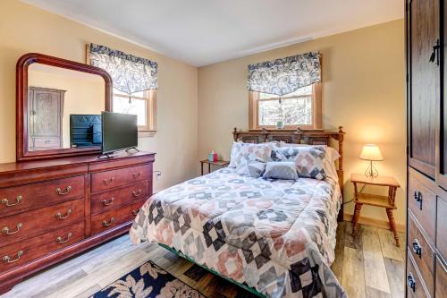 a bedroom with a bed and a television and a dresser at Catskills Getaway with Hot Tub on 45 Acres! in West Coxsackie
