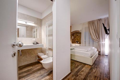 łazienka z łóżkiem i umywalką w pokoju w obiekcie Arcadia Rooms w Meranie