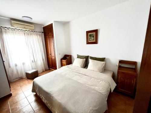 um quarto com uma cama branca e uma janela em Mi Villa em Playa Blanca