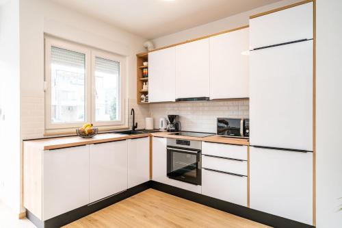 uma cozinha branca com armários brancos e uma janela em Apartment Zoric em Dubrovnik