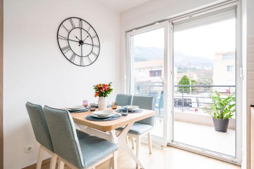 une salle à manger avec une table, des chaises et une horloge dans l'établissement Apartment Zoric, à Dubrovnik