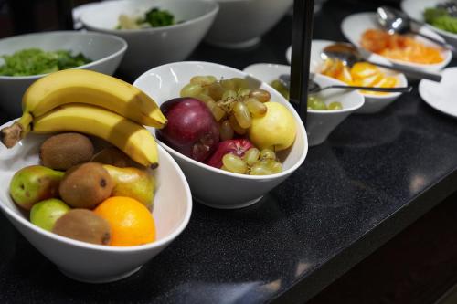 a bunch of bowls of fruit on a table at Ambassador Hotel in Bishkek