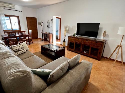 uma sala de estar com um sofá e uma televisão de ecrã plano em Mi Villa em Playa Blanca