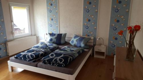 Bett mit blauen Kissen auf einem Zimmer in der Unterkunft Zur alten Wagnerei in Rumbach