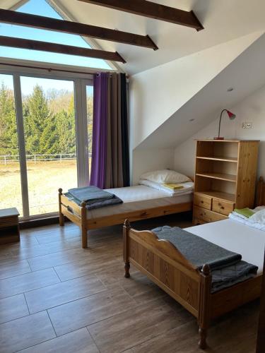 sypialnia z 2 łóżkami i dużym oknem w obiekcie Ośrodek Agroturystyczny Przystanek Koński Dwór w mieście Oborniki Śląskie
