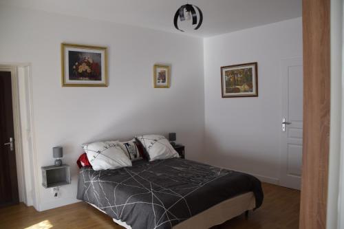 - une chambre avec un lit et deux photos sur le mur dans l'établissement LES 2 CHENES, à Les Riffes
