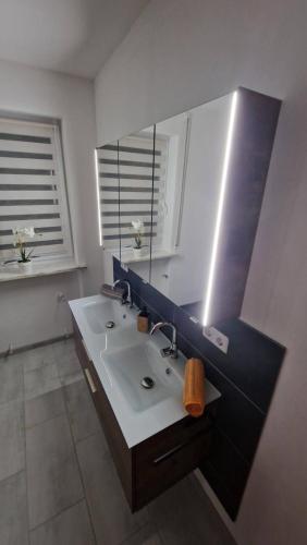 y baño con lavabo y espejo. en Ferienwohnung Wiesental 89331 Burgau, Wiesentalstrasse 1 en Burgau