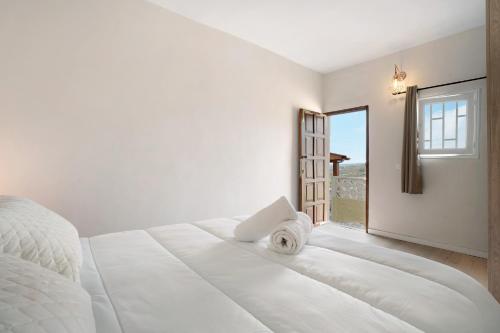 ein weißes Schlafzimmer mit einem großen Bett und einem Fenster in der Unterkunft Finca Lucrecia in Fasnia
