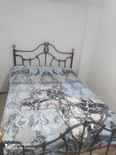- un lit avec une couverture bleue et blanche dans l'établissement Rdc Residence Alakhawayn pour famille, à Ifrane