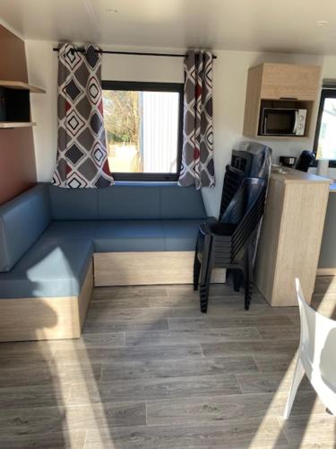 a living room with a blue bench in a trailer at Camping de la Mer in Camiers