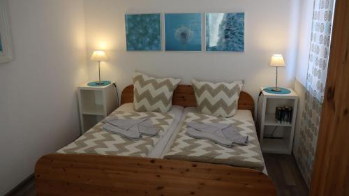 ein Schlafzimmer mit einem Holzbett mit zwei Nachttischen in der Unterkunft Ferienhaus Primavera in Dornumersiel