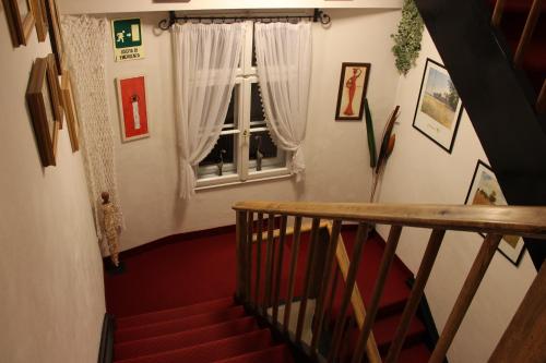 a staircase with a window in a room with red carpet at Hotel Villa Emilia in Ortisei