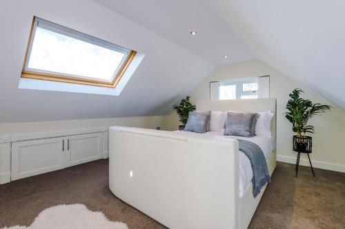 une chambre avec un lit blanc et une fenêtre dans l'établissement "Woodlands" by Greenstay Serviced Accommodation - Luxury 3 Bed Cottage In North Wales With Stunning Countryside Views & Parking - Close To Glan Clwyd Hospital - The Perfect Choice for Contractors, Business Travellers, Families and Groups, à Bodelwyddan