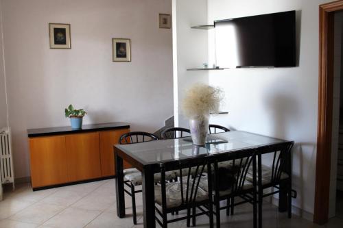 comedor con mesa con sillas y TV en Casa Vacanze Marina Azzurra, en Policoro