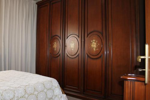 Un dormitorio con una pared de madera y una cama en Casa Vacanze Marina Azzurra, en Policoro