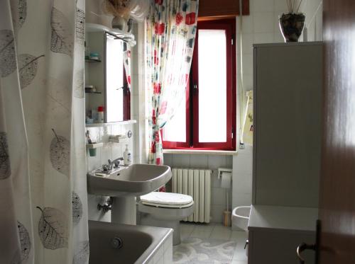 baño con lavabo y aseo y ventana en Casa Vacanze Marina Azzurra, en Policoro