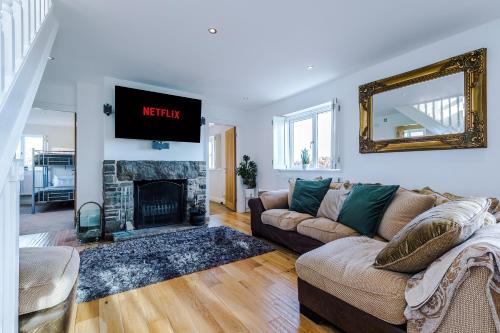 uma sala de estar com um sofá e uma lareira em "Woodlands" by Greenstay Serviced Accommodation - Luxury 3 Bed Cottage In North Wales With Stunning Countryside Views & Parking - Close To Glan Clwyd Hospital - The Perfect Choice for Contractors, Business Travellers, Families and Groups em Bodelwyddan