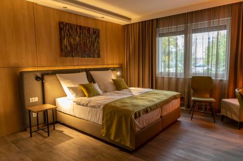 a bedroom with a bed and a window and a chair at Hotel fine art in Rotenburg an der Wümme