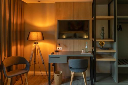 Hotel fine art في روتنبورغ أن در فومه: غرفة بها مكتب مع مصباح وطاولة وكراسي