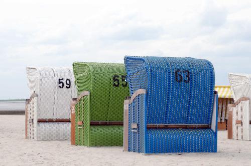 a group of chairs sitting on the beach at Ferienhaus Sunny, FeWo Vermittlung Nordsee in Dangast
