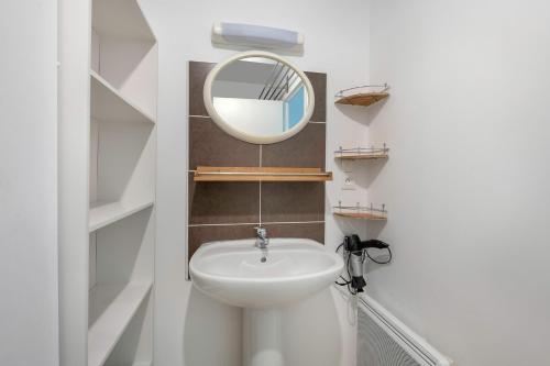 a bathroom with a sink and a mirror at Appartement a 1km de la mer! in Piriac-sur-Mer